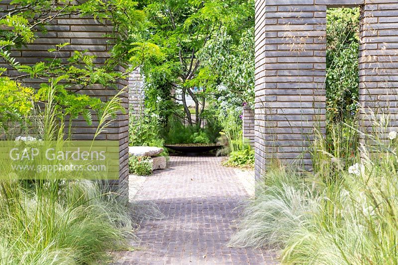 Jardin d'herbes ornementales divisé par des colonnes et des murs de pavés en brique de Belgique. Jardin du sanctuaire RHS - Festival des fleurs de Hampton Court 2019