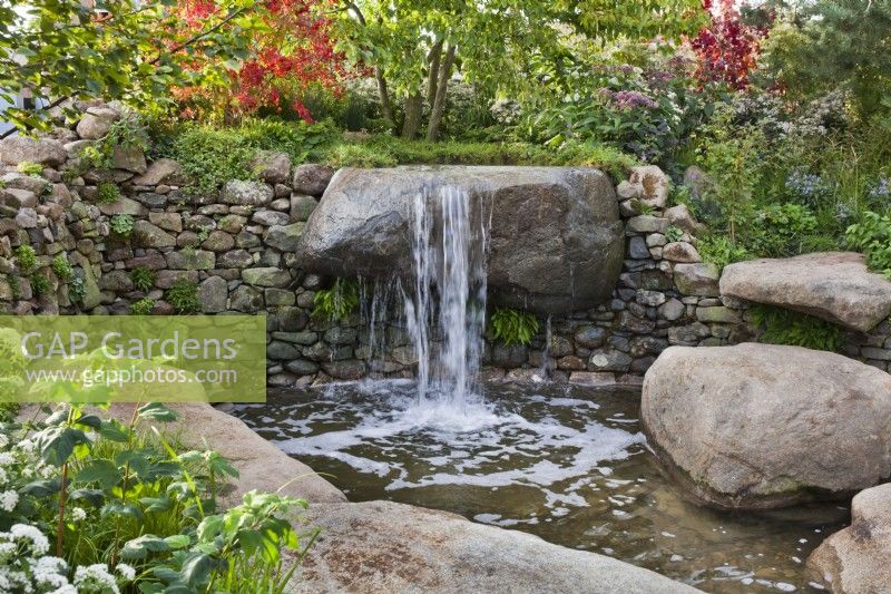 Jeux d'eau dont une petite cascade et une piscine. Le jardin du Psaume 23 au Chelsea Flower Show 2021.