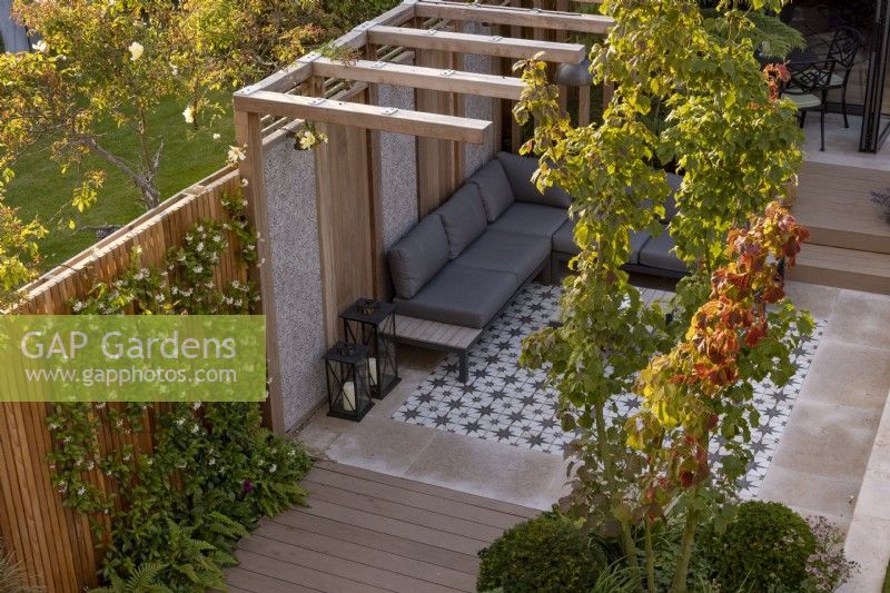 Vue élevée du jardin de banlieue contemporain avec pergola et coin salon avec terrasse Acer rufinerve en premier plan