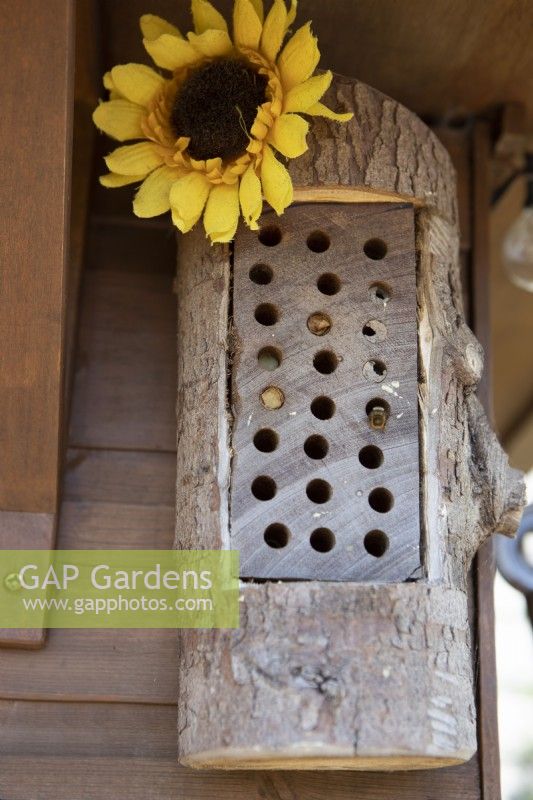 Un hôtel à abeilles fait maison, installé dans les chevrons d'une maison d'été, attire les abeilles solitaires.