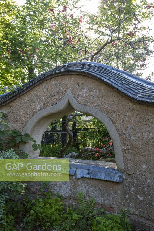 Structure murale en torchis dans le jardin, avec fenêtre en arc 'judas'