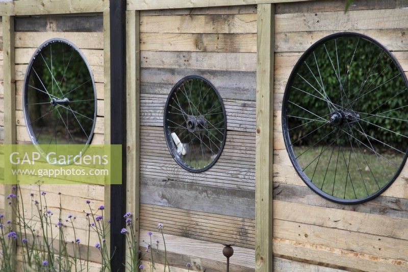 'On Your Bike!' au BBC Gardener's World Live 2021 - des panneaux de clôture avec des roues de vélo sous forme de formes découpées dans un jardin sur le thème du cyclisme