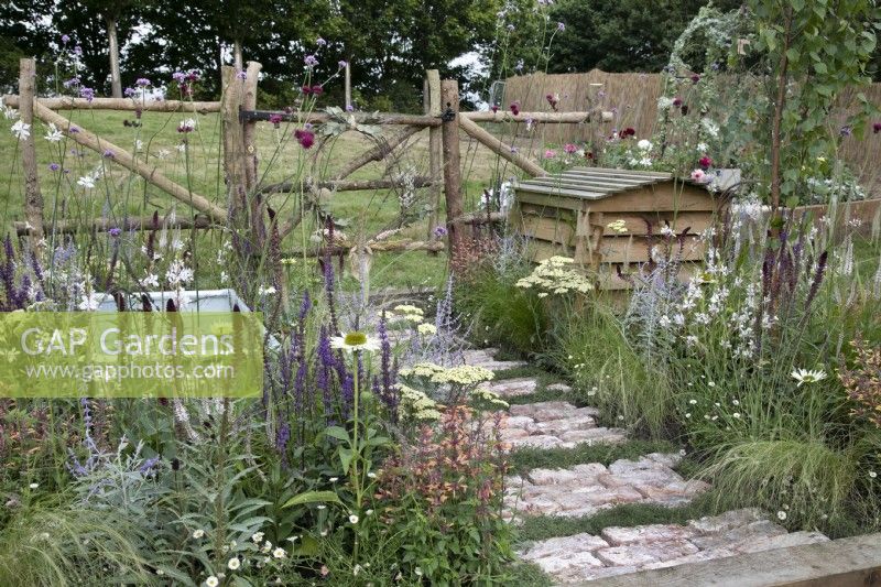 'The Earth Smiles with Flowers' au BBC Gardener's World Live 2021 - jardin de campagne avec chemin rustique en briques et camomille, ruche et plantation de vivaces en sourdine