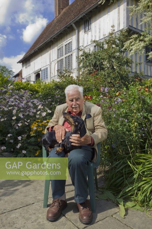 Christopher Lloyd avec pet teckel à côté du long parterre de fleurs à Great Dixter, East Sussex, Angleterre