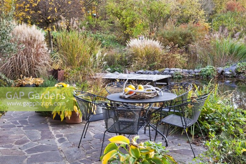 Aire de détente, bassin et platebande colorée avec graminées, vivaces et arbustes. Jardin de Gisi Helmberger, Autriche