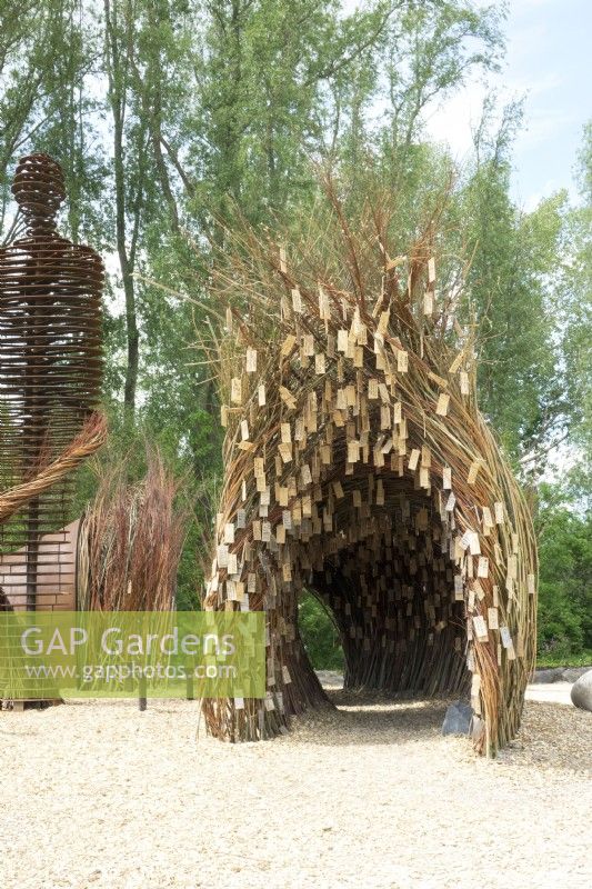 Arche faite de branches de saule avec des plaques de souhaits en bois réalisées par l'artiste de la nature Will Beckers.