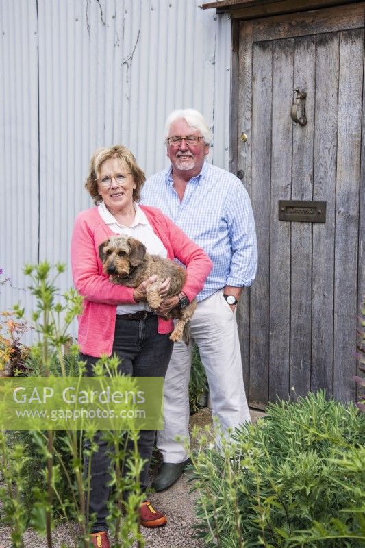 Couple avec chien debout près d'une porte