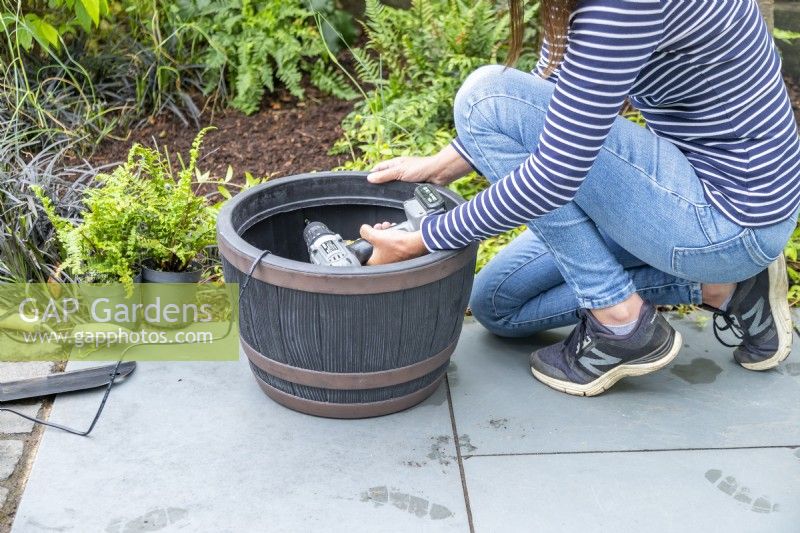 Femme perçant un trou dans le pot pour y faire passer le fil