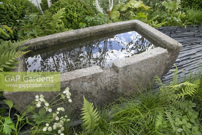 Abreuvoir en pierre dans le jardin des connexions au RHS Hampton Court Palace Garden Festival 2022