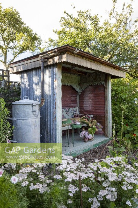 Plantation de chalets informels autour d'une maison d'été faite de matériaux recyclés.