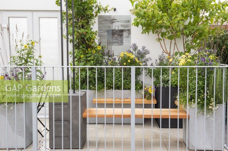 Bancs en bois attachés à de grandes jardinières avec plantation de vivaces à la fin de l'été - The Landform Balcony Garden, RHS Chelsea Flower Show 2021