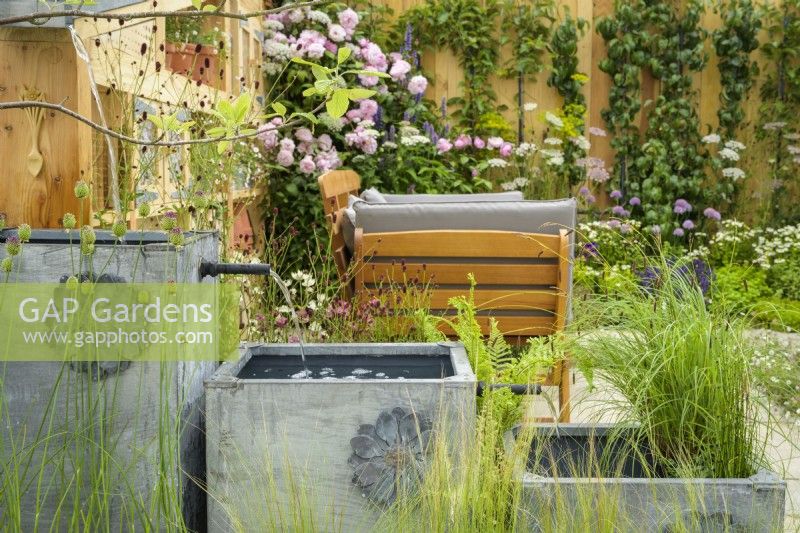 Trois pots à effet de plomb utilisés comme dispositif d'eau en cascade avec plantation - Knolling avec Daisies, RHS Hampton Court Palace Garden Festival 2022