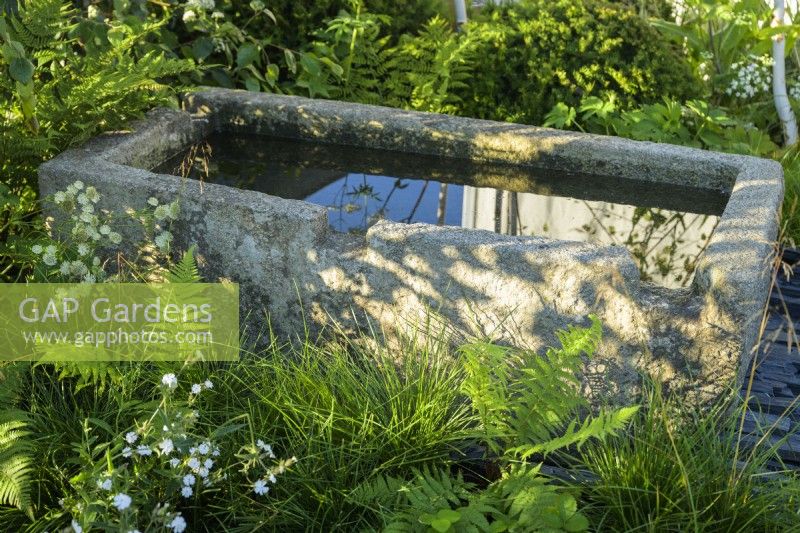 Ancien bac à eau en pierre dans le jardin des connexions au RHS Hampton Court Palace Garden Festival 2022