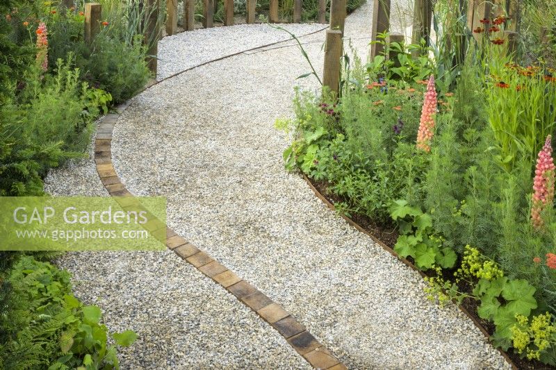 Chemin de gravier incurvé avec ligne centrale de briques - A Journey, en collaboration avec Sue Ryder garden au RHS Hampton Court Palace Garden Festival 2022
