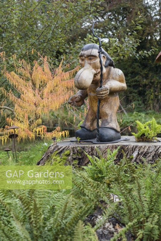 Troll en bois sculpté sur une souche d'arbre au jardin de John Massey en octobre.