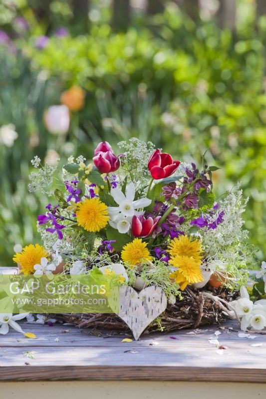 Arrangement floral printanier avec tulipes, jonquilles, pissenlit, persil de vache, honnêteté et lamier.