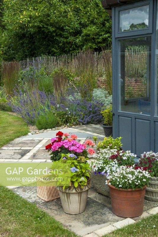 Patio décoratif avec plantes en pot et parterre de graminées sèches et vivaces menant de la maison d'été - Journée des jardins ouverts, Easton, Suffolk