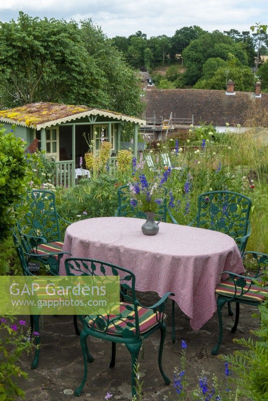 Table avec nappe et chaises à carreaux pour les repas en plein air, donnant sur la pelouse inférieure et le pavillon d'été avec toit en sedum vivant - Journée des jardins ouverts, Tuddenham, Suffolk