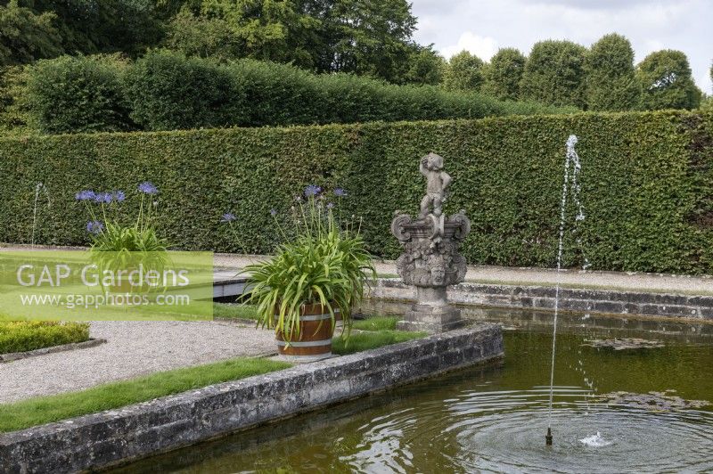 Hanovre Allemagne Jardins royaux de Herrenhausen. Inselgarten. Jardin de l'île. Avec des statues, une pièce d'eau avec une île et des agapanthes en pots.