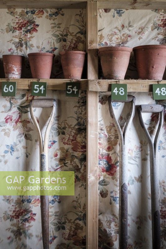 À l'intérieur d'un abri de jardin avec une collection de pots de plantes en terre cuite d'époque organisés par taille