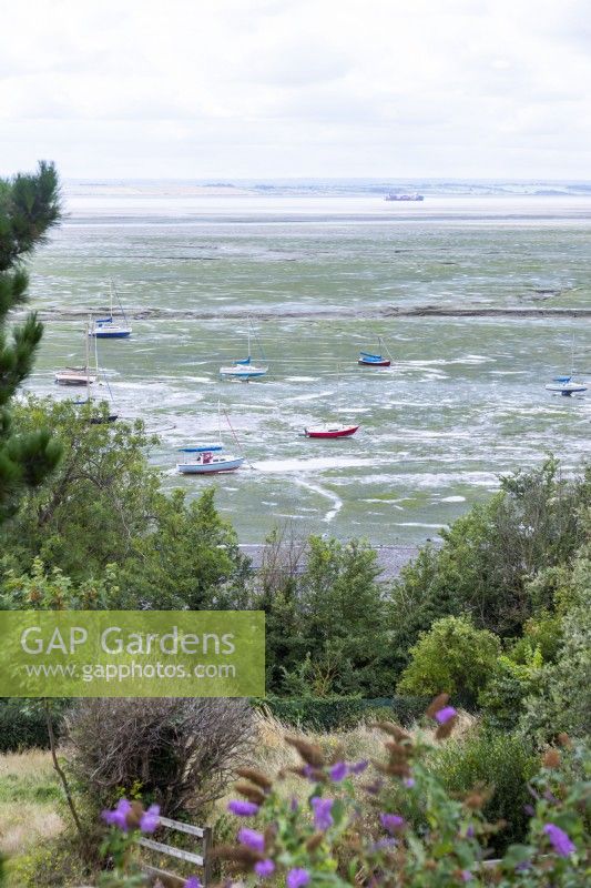 Vue sur le front de mer avec marée basse et bateaux éparpillés sur le rivage
