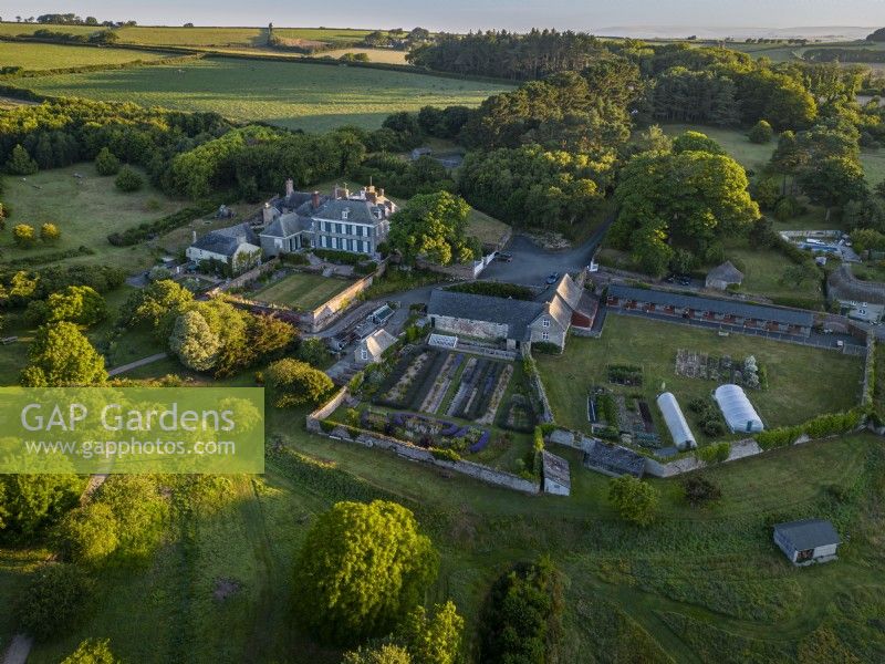 Vue aérienne de Mothecombe House dans le Devon, un bâtiment Queen Ann avec de vastes jardins situés dans la campagne vallonnée du Devon