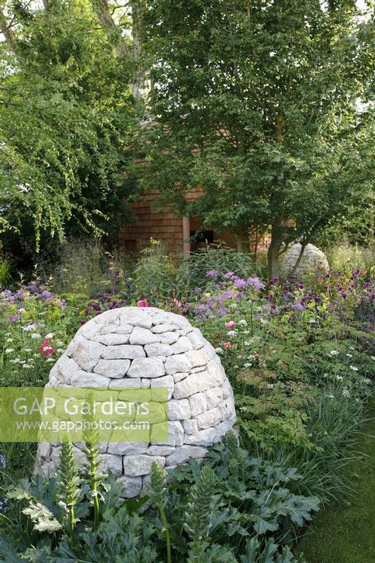 Des cairns de pierre se trouvent parmi les plantations herbacées, notamment l'acanthe « Rue Ledan » dans le jardin d'Horatio - Designer : Charlotte Harris et Hugo Bugg - Sponsor : Project Giving Back -