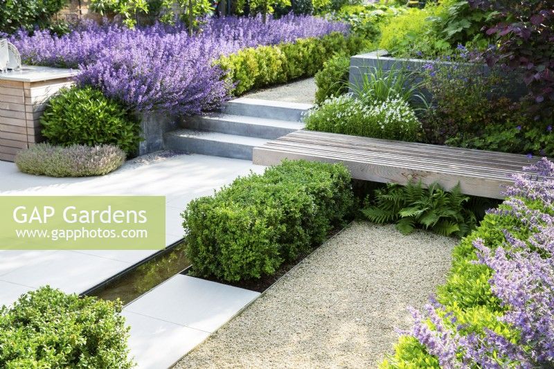 Jardin formel moderne avec différentes surfaces et couleurs violettes et vertes