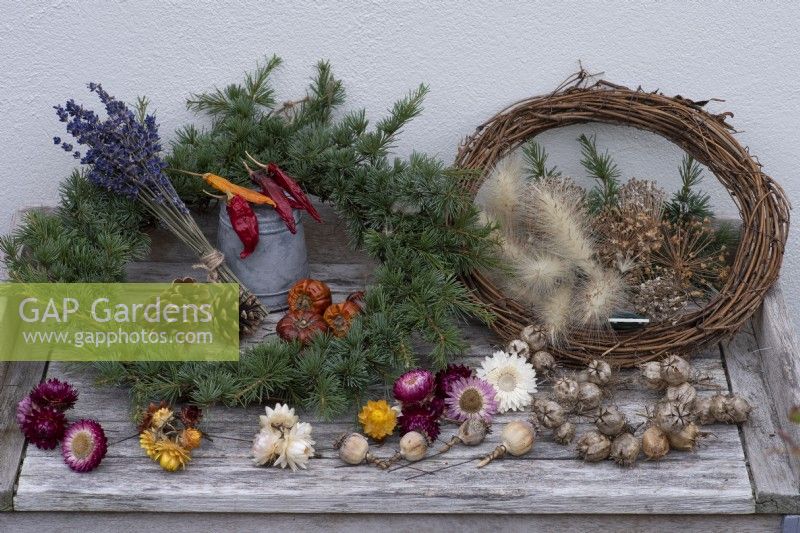 Une couronne de guirlande de jardinier. Vous aurez besoin d'un cadre tissé recouvert de feuillage d'épicéa, de fleurs séchées, de cônes, de graines câblées et de fruits à décorer.