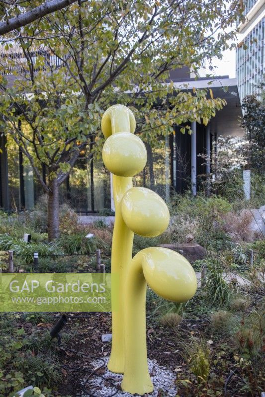 Sculpture abstraite en métal peint en jaune dans le jardin Sprouting. 