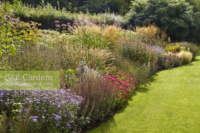 Grande herbe ornementale et parterre de fleurs vivaces dans le jardin familial privé de Cambo House, Fife, Écosse. 