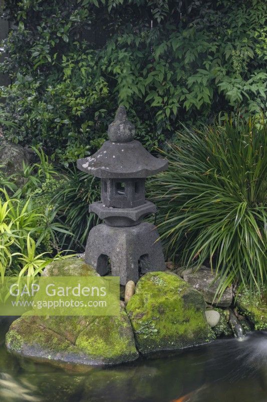 Étang de carpes Koi avec lanterne de pagode japonaise en pierre. 
