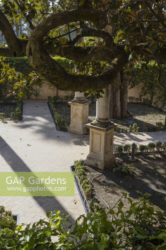 Une vue sur une cour avec des chemins et des colonnes ornées. Jardins du véritable palais de l'Alcazar, Séville. Espagne. Septembre. 