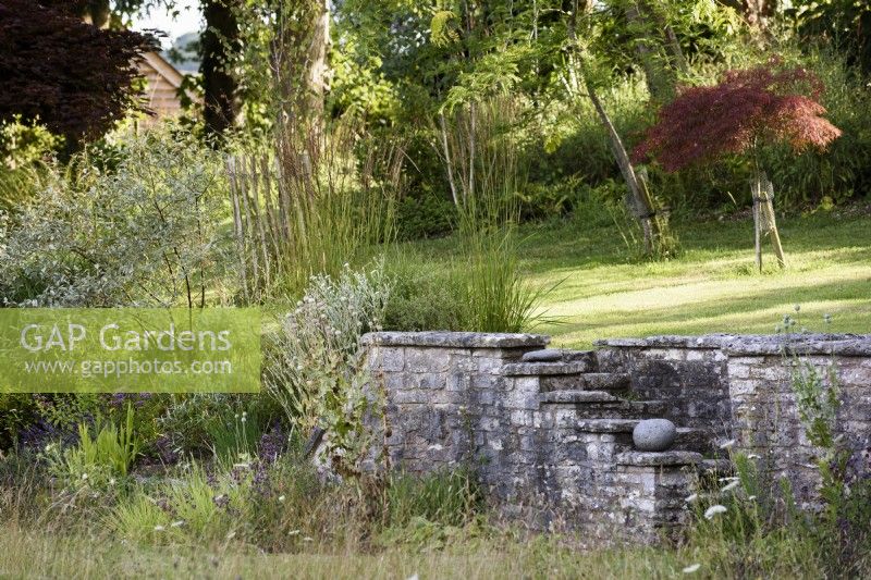 Mur de pierre et marches dans un jardin de campagne en juillet 