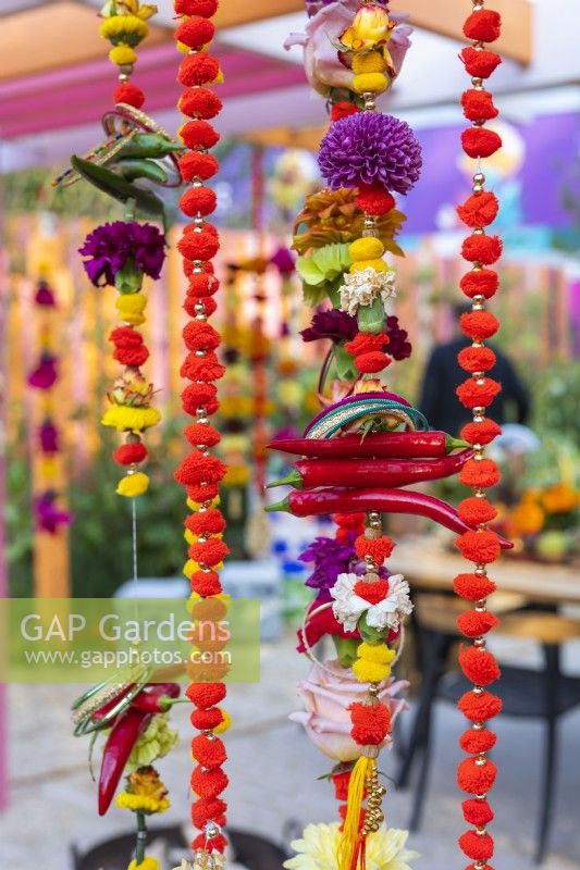  Guirlandes de soucis composées de fleurs, piments, fruits, pompons en laine et bracelets. Le RHS et Eastern Eye Garden of Unity, concepteur : Manoj Malde. 