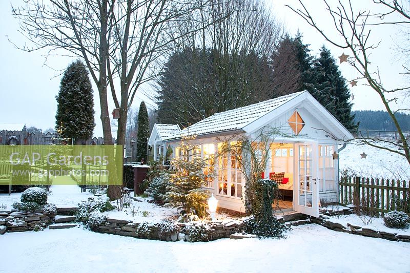 Maison de jardin éclairée en hiver 