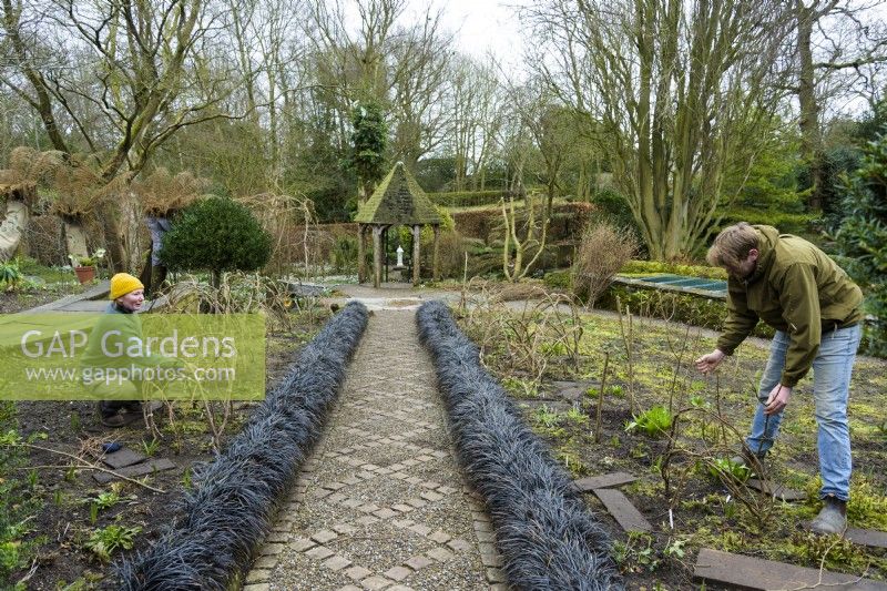 Jardiniers construisant des supports de noisetiers pour plantes herbacées vivaces au York Gate Garden en février 