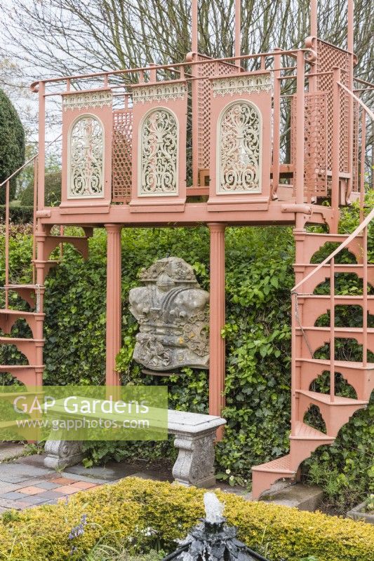 Double escalier en colimaçon métallique et plate-forme panoramique avec banc en pierre dans le jardin Howdah. Avril. Printemps. 