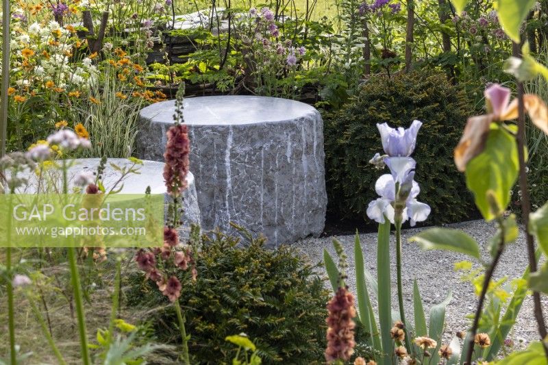 Des morceaux ronds de pierre forment des sièges dans le Macmillan Legacy Garden - designers Kerianne Fitzpatrick et TJ Kennedy - RHS Malvern Spring Festival 2024 