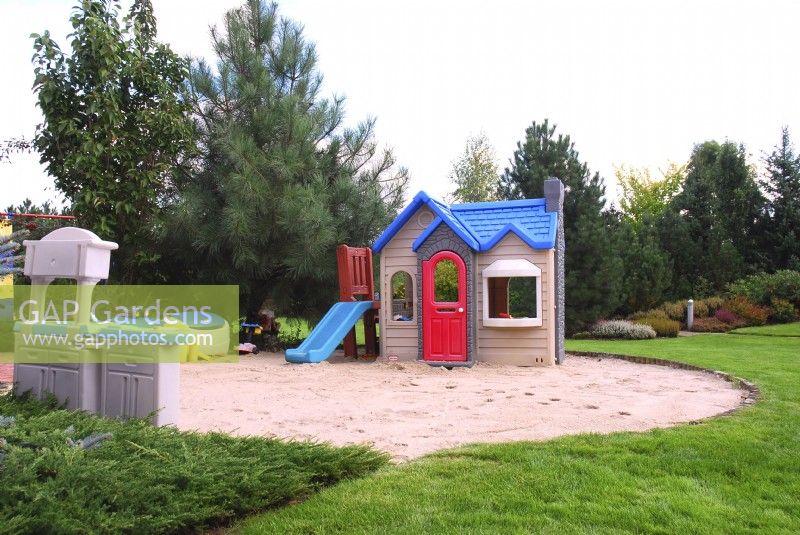 Une aire de jeux pour les petits enfants dans un bac à sable circulaire dans le jardin d'été. 