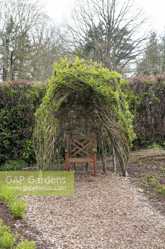 Harrogate Yorkshire UKRHS Harlow Carr Jardins. Potagers. Des saules tissés pour former un abri au-dessus d'une chaise en bois. 