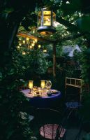 L'éclairage de la salle à manger extérieure sous pergola dans le jardin à Park Terrace dans le Sussex