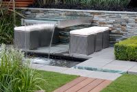 Coin salon extérieur avec une fontaine d'eau de table et une piscine, pavage et éléments de paysage dur