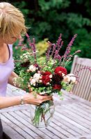 Femme, organiser, frshly, choisi, fleurs, vase, table jardin
