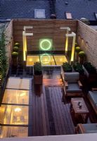 Jardin sur le toit contemporain avec canapé en bois, éclairage et sphères Buxus en pots - Wilton Place Londres
