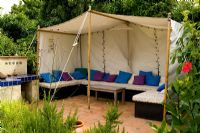 Coin salon sous tente dans un jardin à thème marocain