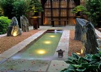 Jardin japonais montrant une longue piscine avec des lumières sous-marines