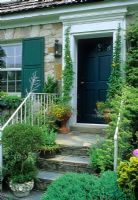 Jardin avant de maison avec porte verte, marches, rampes et pots - USA