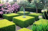 Jardin à la française avec Buxus coupé et petite statue figurative