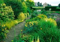 Arbustes et herbes à feuilles d'or bordent le jardin fleuri - Herterton House, nr Cambo, Morpeth, Northumberland